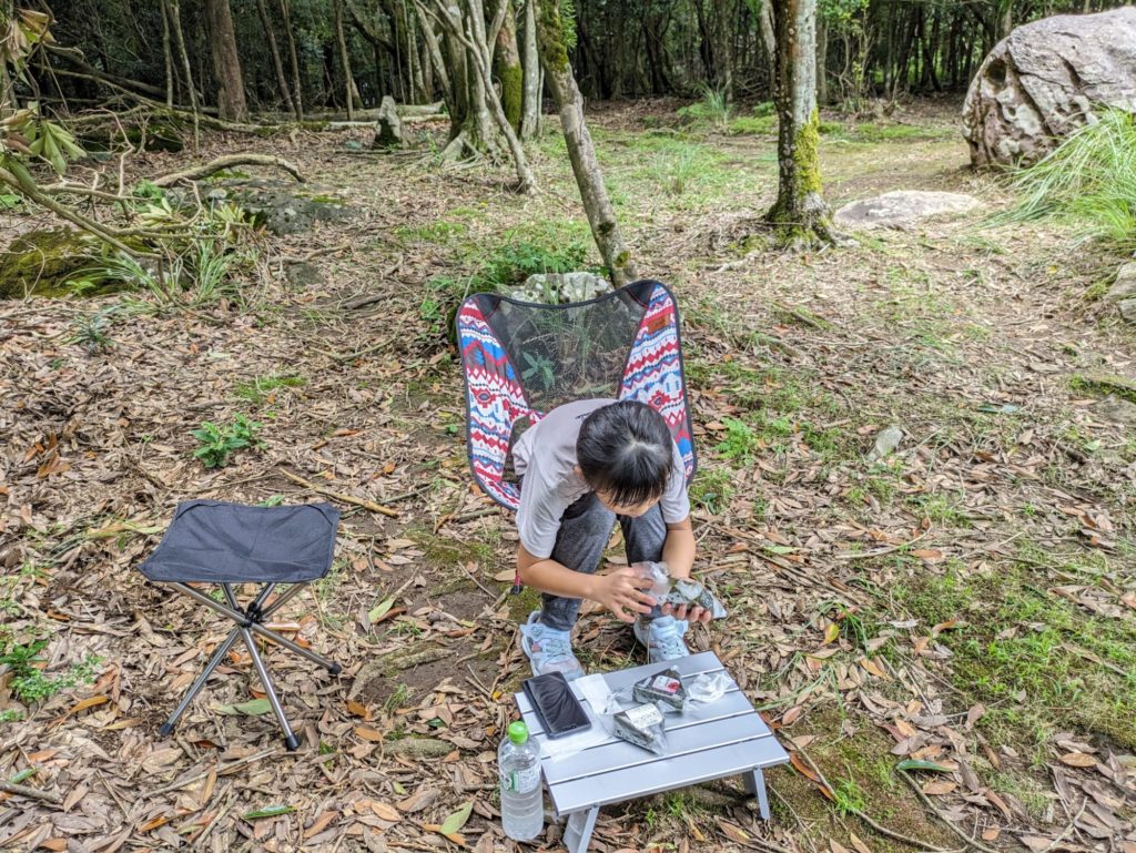 山頂でおにぎりを食べる子ども